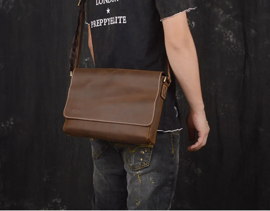 Vintage brown leather men's messenger bag with flap opening and adjustable shoulder strap.