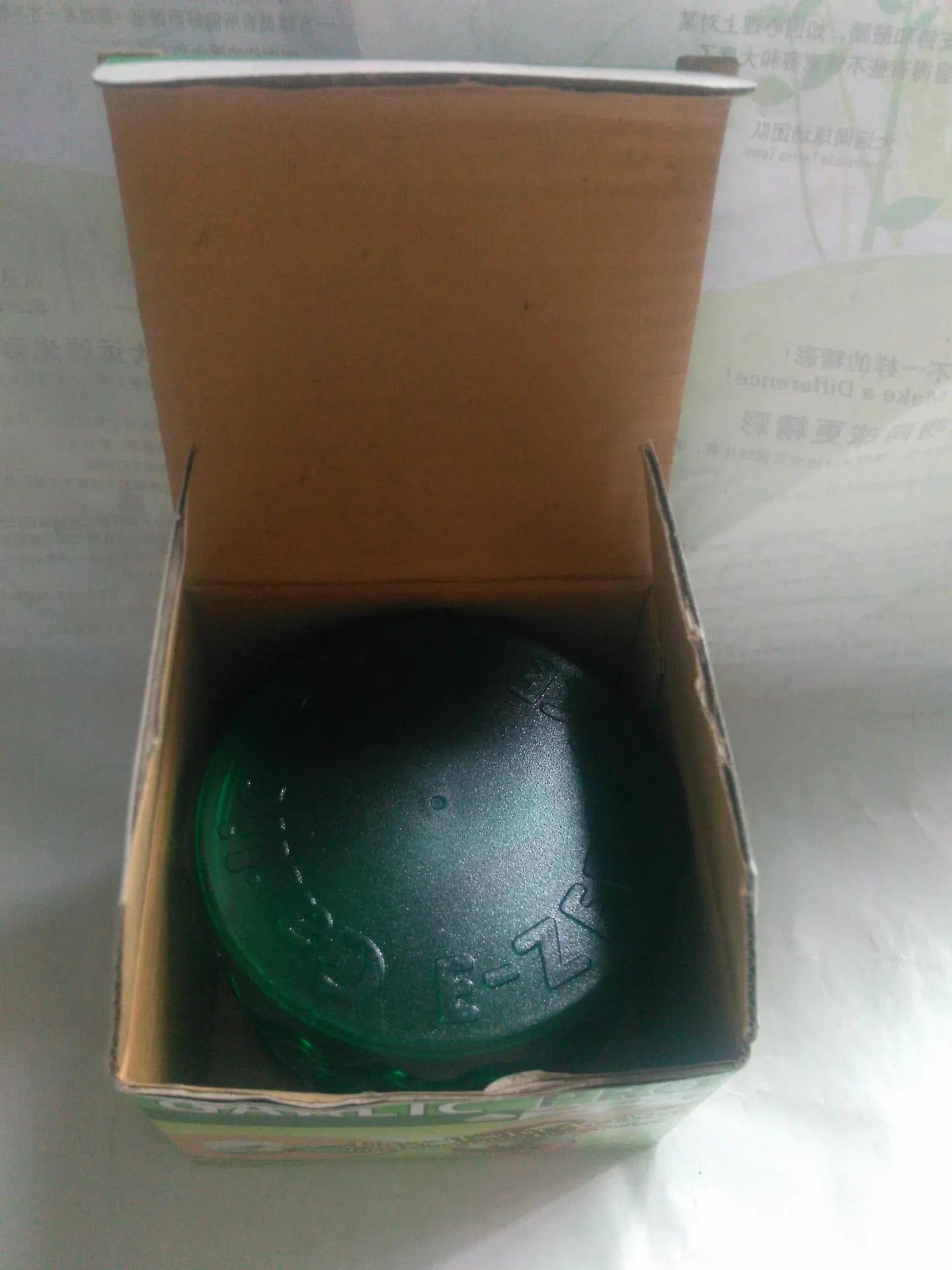 Green transparent polypropylene garlic peeler on a kitchen counter