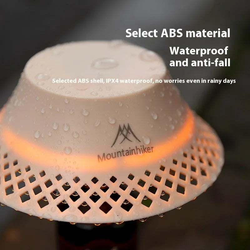 Beige and grey portable camping lantern with a wine bottle shaped lampshade and USB-C charging port.