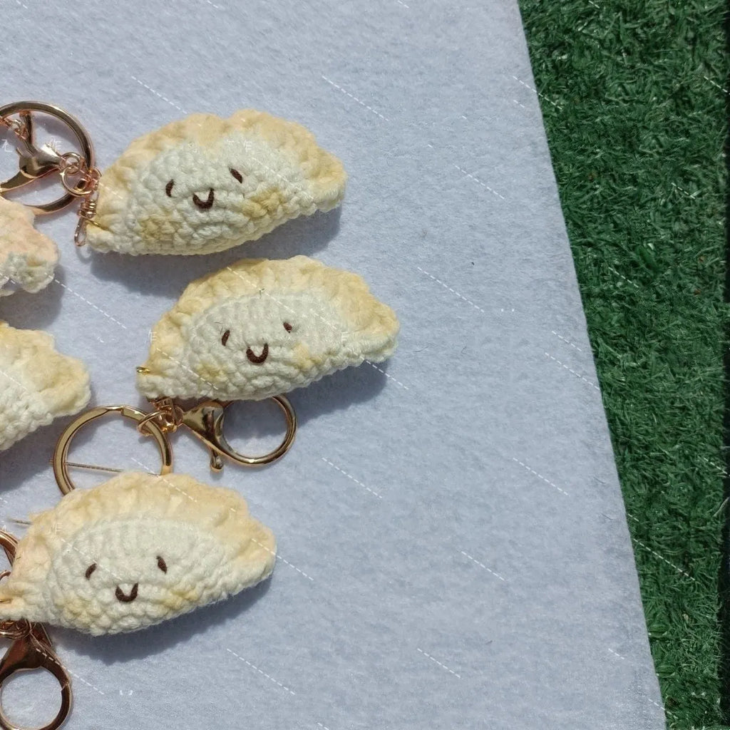 Handmade crochet dumpling pendant with keychain in plush material showing hand-stitched eye details
