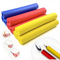 Set of black rubber grip hoses for organising tableware and pen handles in a drawer.