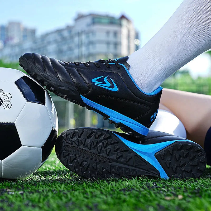 Low-top turf soccer shoes in black and white broken nails colour with synthetic leather upper