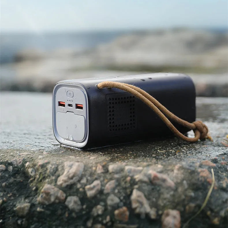 Black portable power bank with digital display, solar panel, and 220V AC outlets for outdoor use.