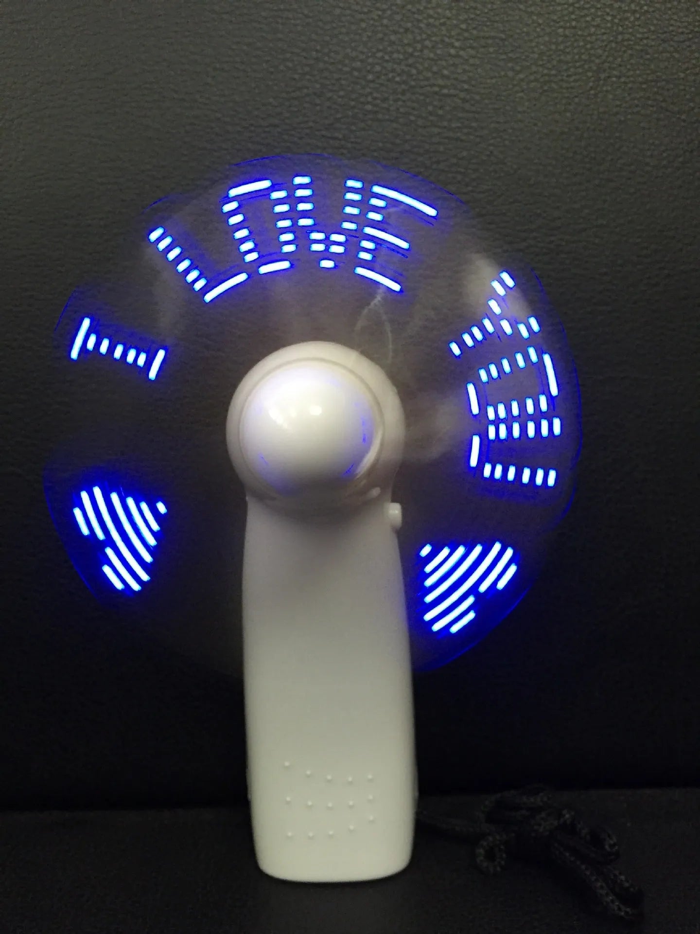 White handheld mini fan with a blue and red LED 'I love you' display lit up.