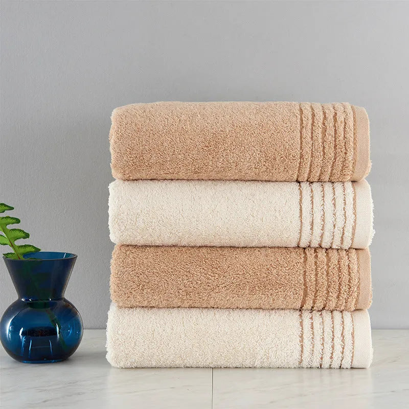 Beige and brown cotton towel set showing face cloth, hand towel and bath towel sizes.