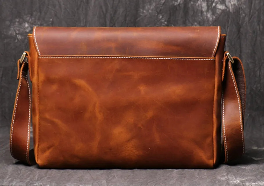 Vintage brown leather men's messenger bag with flap opening and adjustable shoulder strap.
