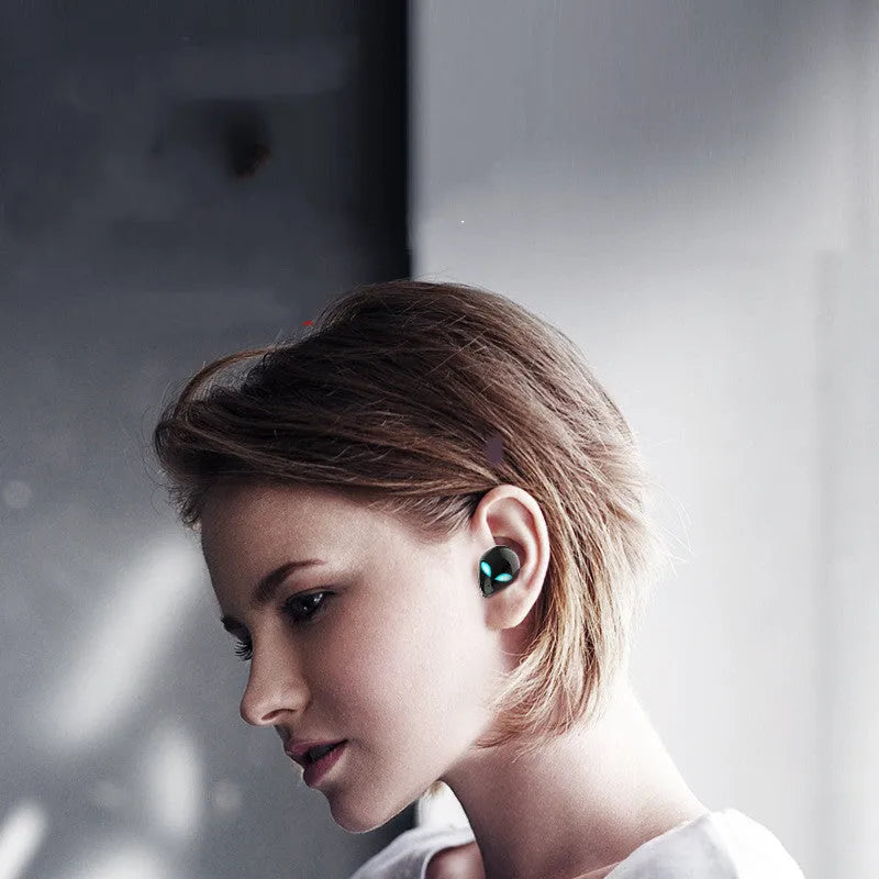 Creative Outer T8 Starman alien-design Bluetooth headset with red and blue lights in charging case.