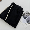 Men's loose-fitting straight-leg casual pants in beige colour with an elasticated drawstring waistband.