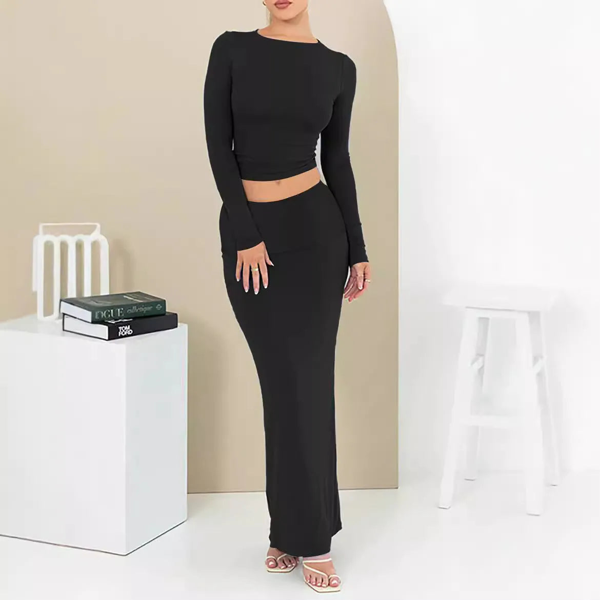 Women's slim fit polyester two-piece suit set with top, long skirt, and exposed navel detail.