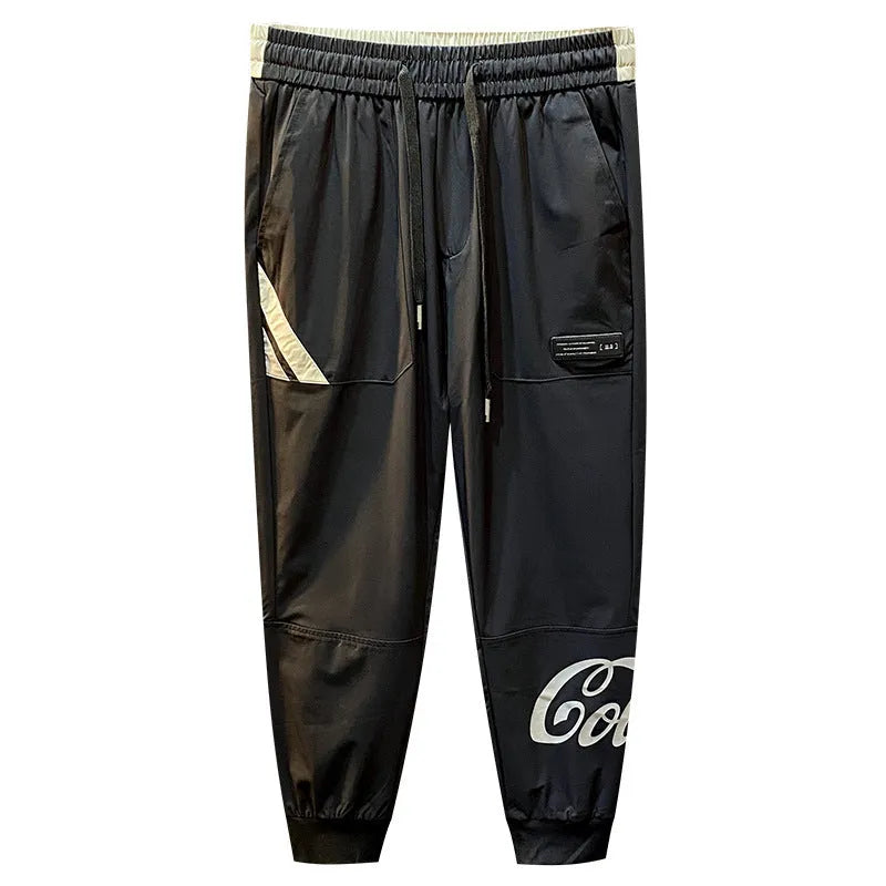 Men's solid black ultra-thin cotton cropped trousers with ankle banding on a casual model.