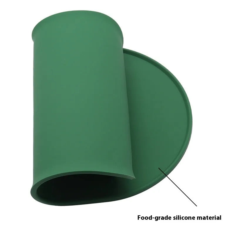 A green silicone placemat for cats with a non-slip base, shown under a food bowl.