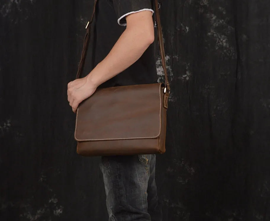 Vintage brown leather men's messenger bag with flap opening and adjustable shoulder strap.