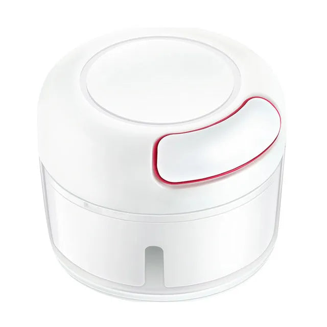 White manual food chopper with stainless steel blades on a magnet, shown with garlic and vegetables.