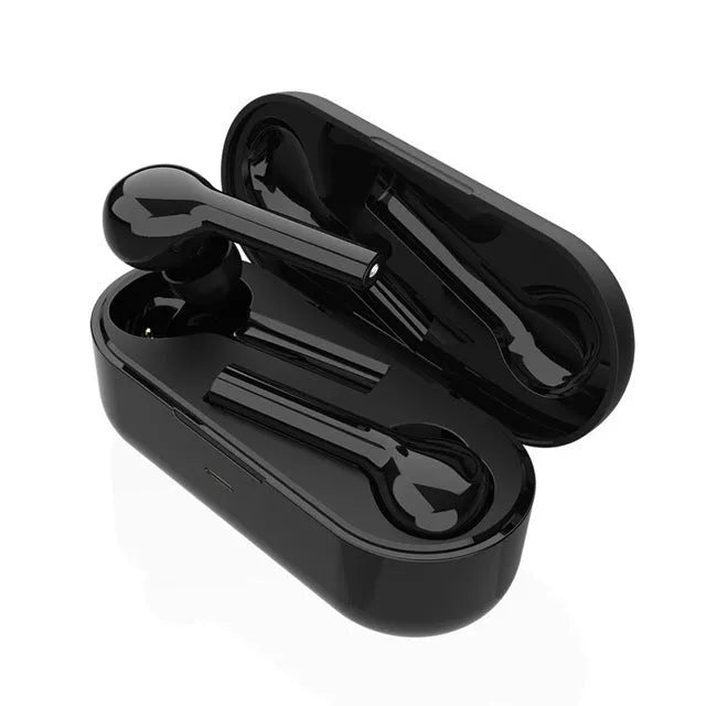 Black and white wireless in-ear Bluetooth headphones with a charging case on a table.