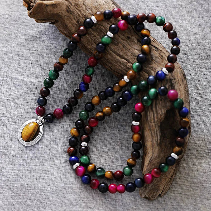 Close-up of a tiger-eye stone bead necklace with 108 gem-inlaid pendants showing heart, crown, and infinite symbols.