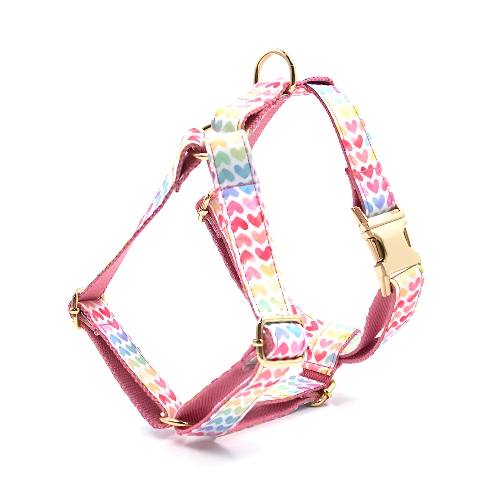 Pink dog harness with colourful heart-shaped stones and a gold-coloured buckle on a white background.