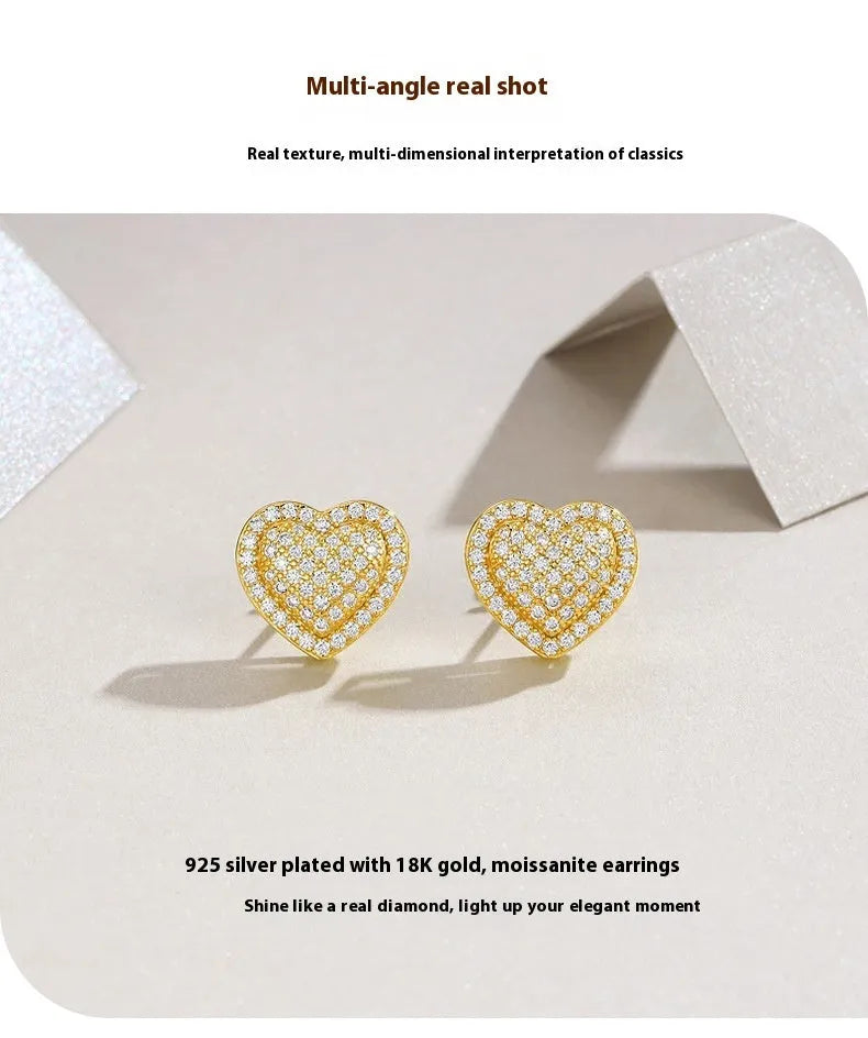 A pair of golden heart-shaped moissanite stud earrings on an S925 silver post.