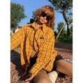 Yellow and black plaid shirt with a loose cardigan-style fit on a hanger.