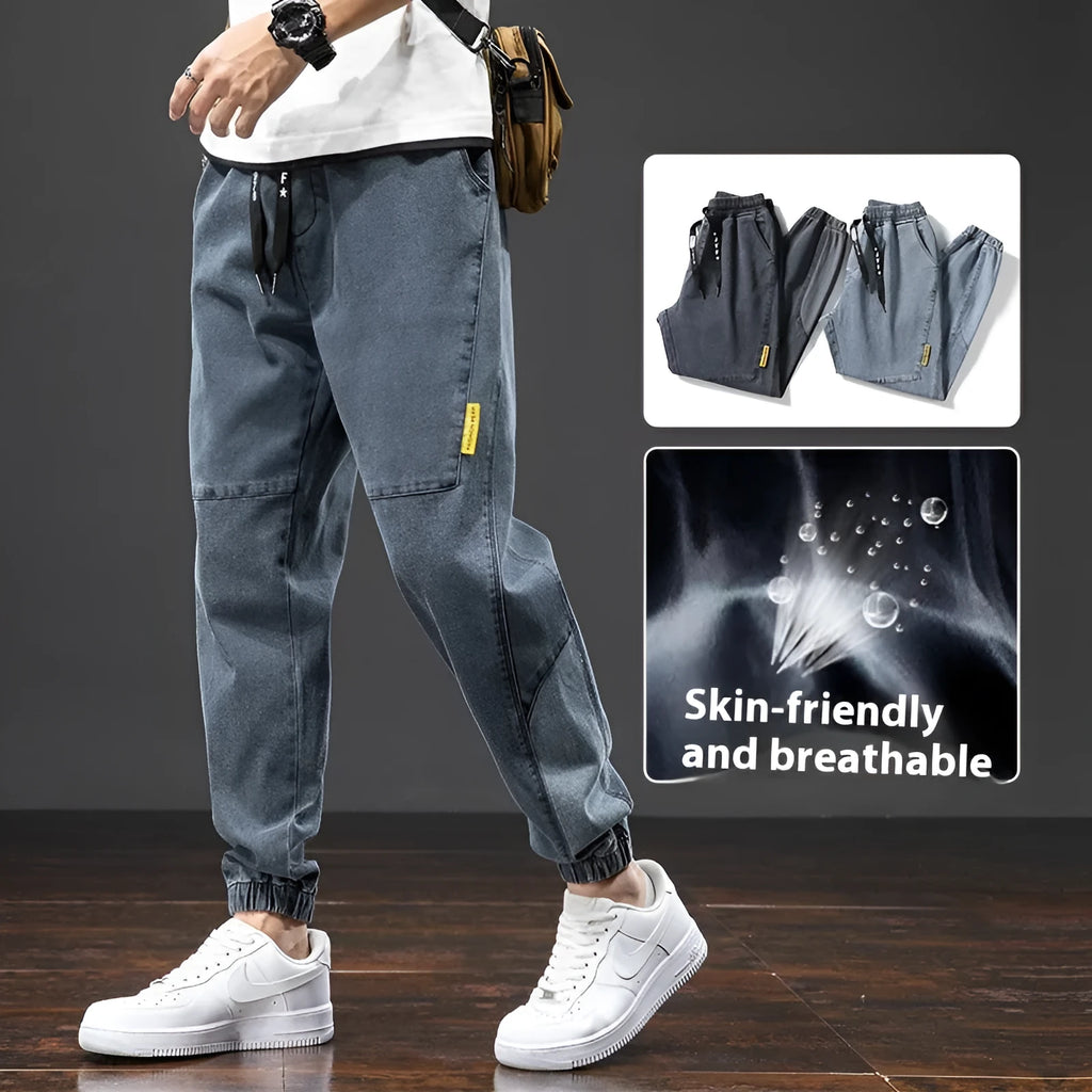 Men's loose fit straight leg cargo jeans in blue on a neutral background.