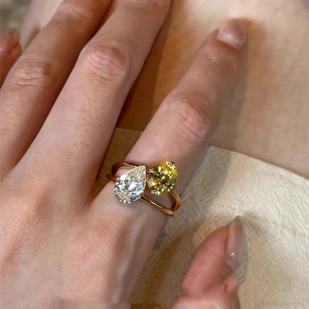 Geometric open copper ring with a water drop double Sheng stone zircon centrepiece.