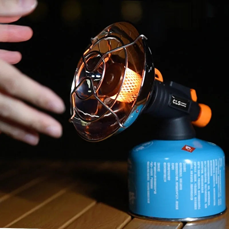 Black and orange portable outdoor heating stove with automatic ignition on a table.