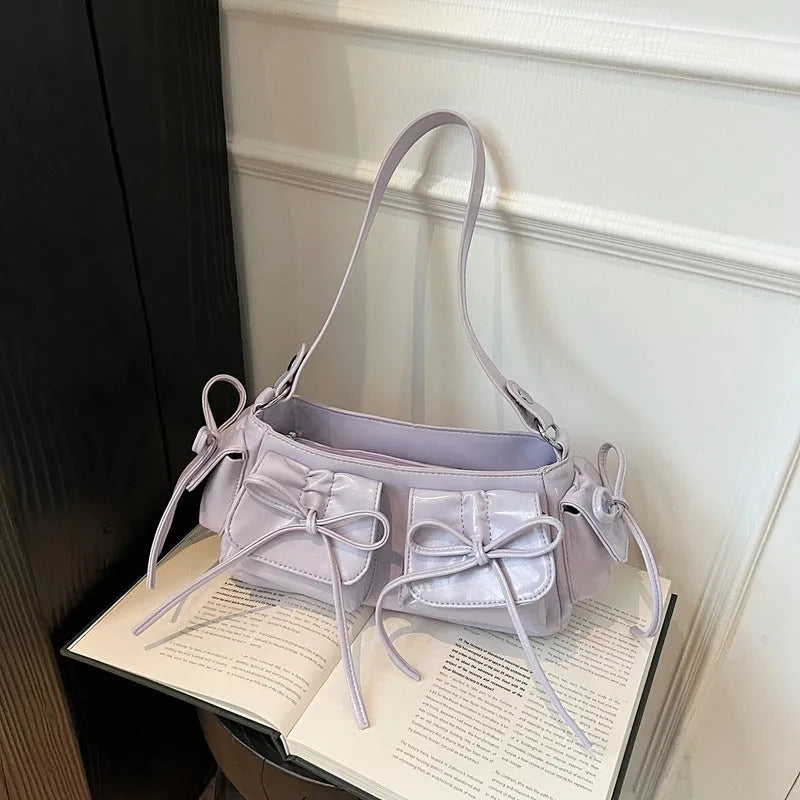 Women's shoulder bag with tassel bow decoration and multi-pocket design in various colour options