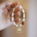 Chinese style women's glass bracelet with fu character and safety lock charms.