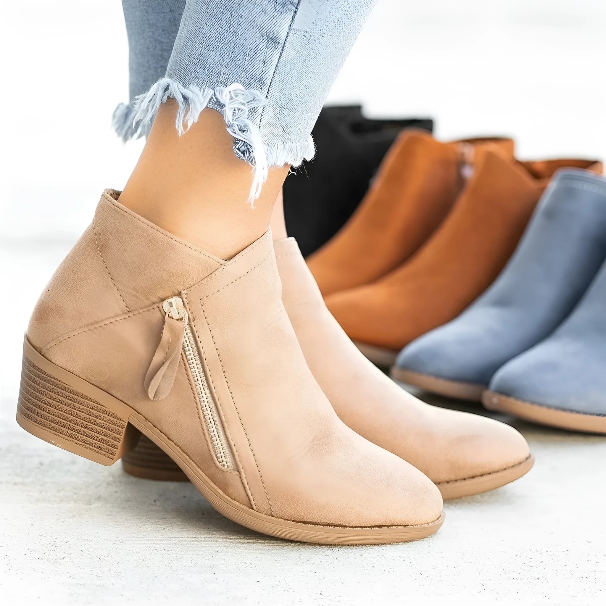 Women's suede ankle boots with side zip and chunky heel in beige, shown from the side.
