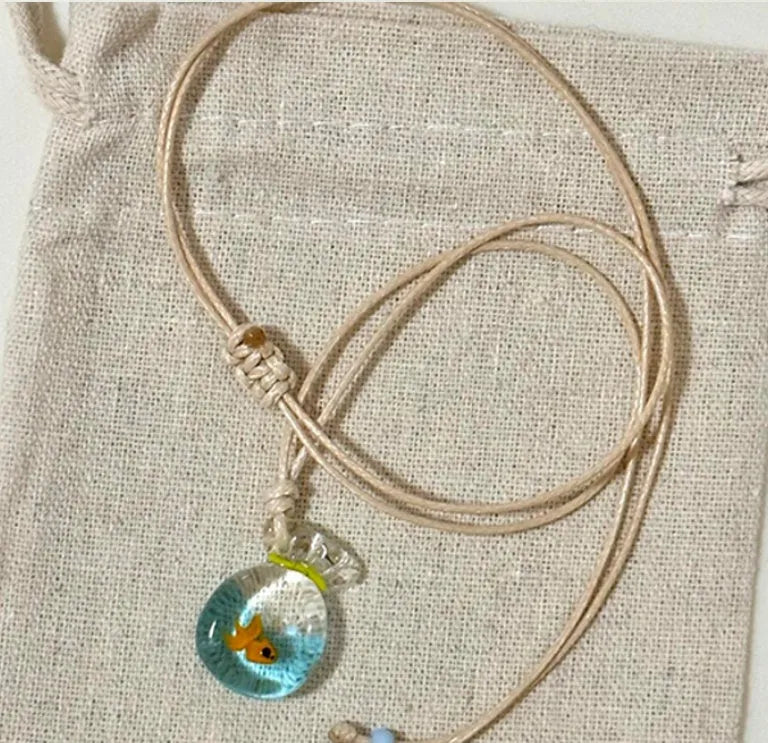 Women's pendant necklace with coloured glaze joker charm on a cotton and linen clavicle chain.