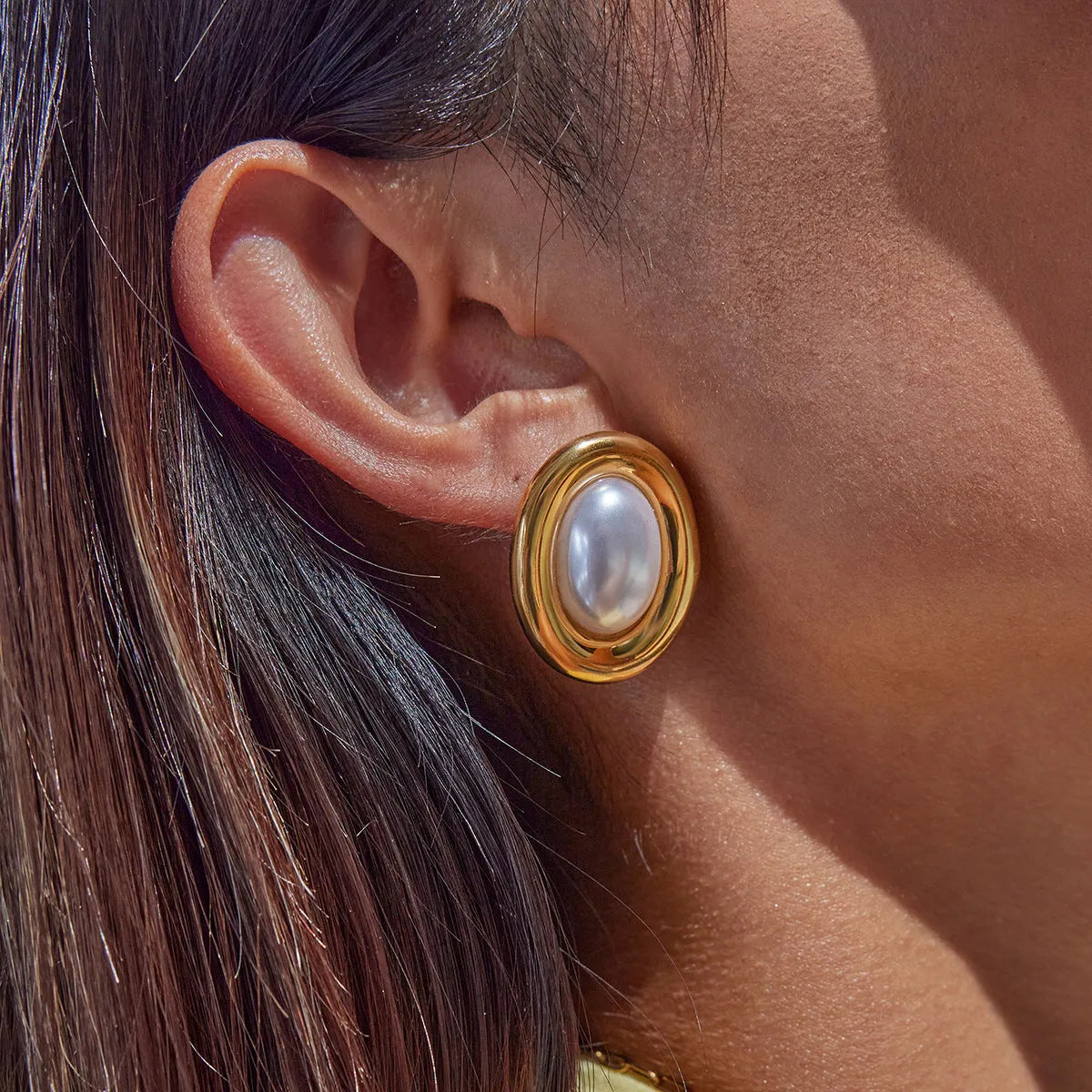 A pair of stainless steel stud earrings with a vintage-style pearl accent in colour JDE0305051.