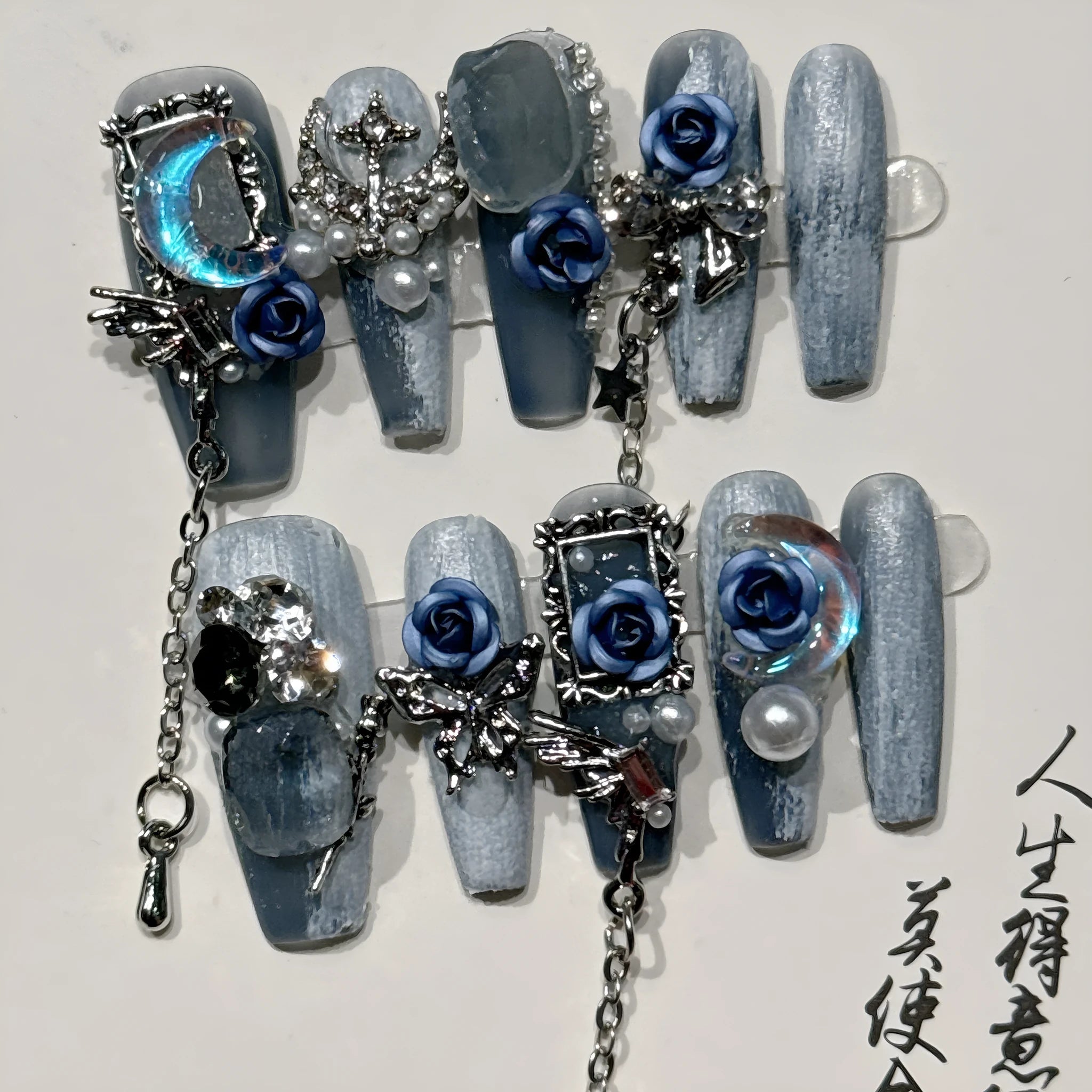 False nails with ornate rose and floral pattern in dark blue, showing sizes XS, S, M, L.