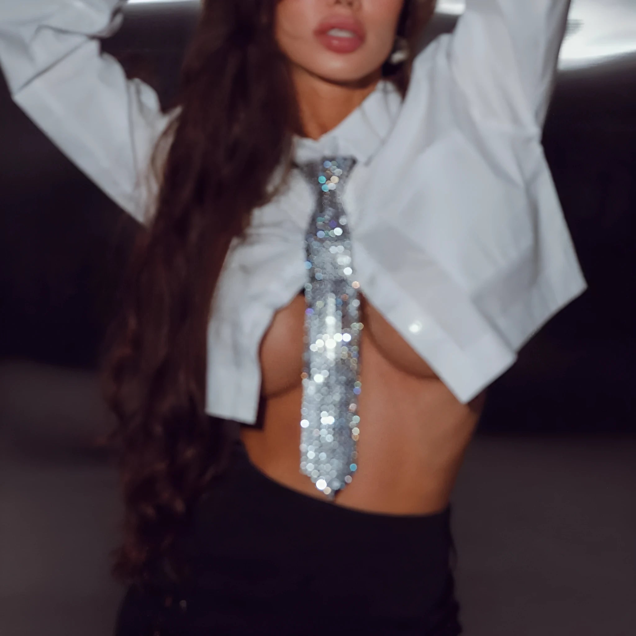 Silver metal sequin bow tie with arrow-style pointed ends on a black background