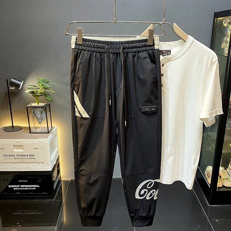 Men's solid black ultra-thin cotton cropped trousers with ankle banding on a casual model.