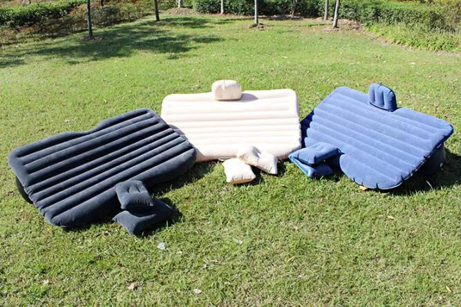 Inflatable car bed with flocked surface and two pillows, shown inside a five-seater vehicle.