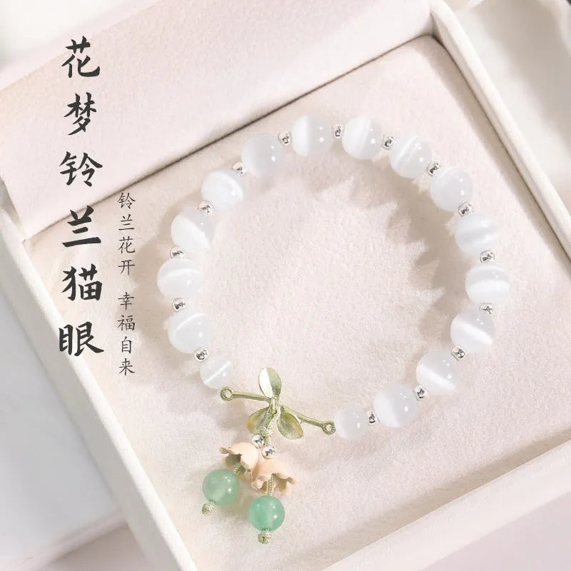 Women's opal cat's eye stone bracelet with diamond-shaped beads on wrist.
