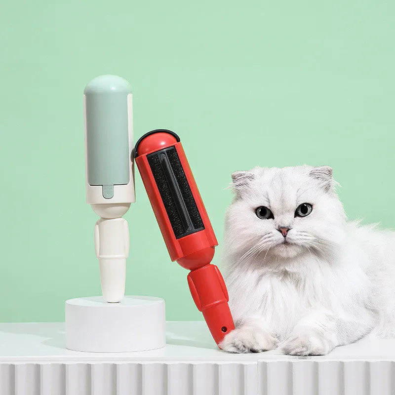 White and green reusable pet hair remover roller with a non-slip handle on a fabric sofa.