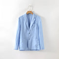 Men's thin linen suit coat in a solid colour on a hanger, showing stick pocket detail.
