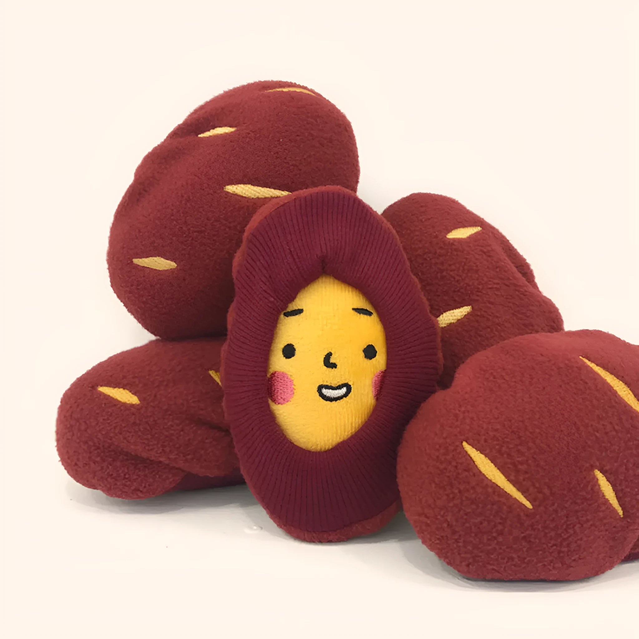 Red sweet potato dog puzzle toy with removable peel showing internal treat pockets