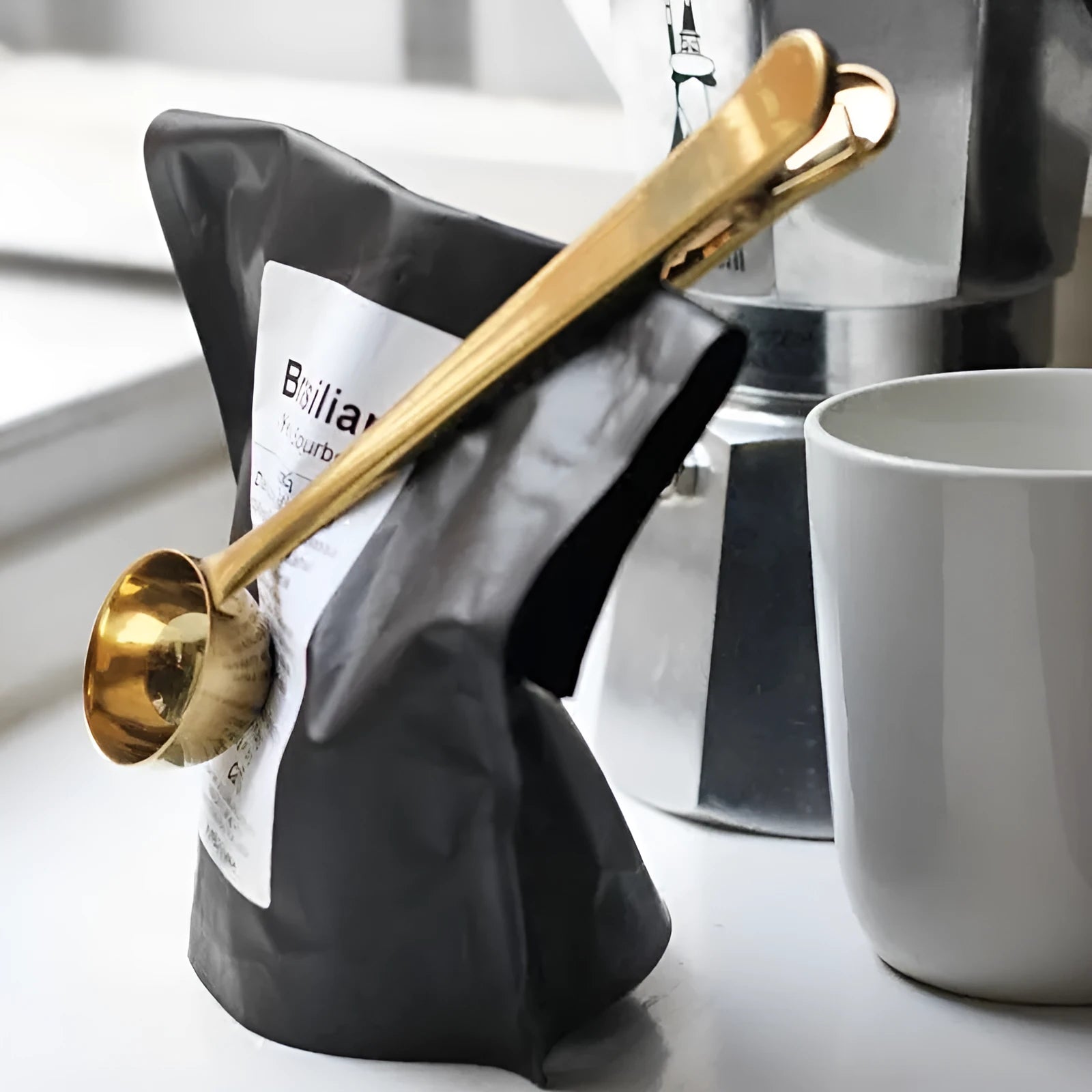 Silver stainless steel coffee scoop with integrated bag clip and belt hanger.