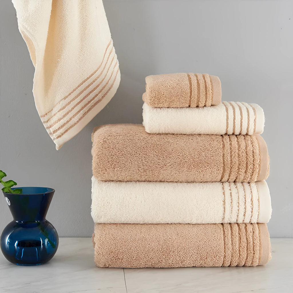 Beige and brown cotton towel set showing face cloth, hand towel and bath towel sizes.
