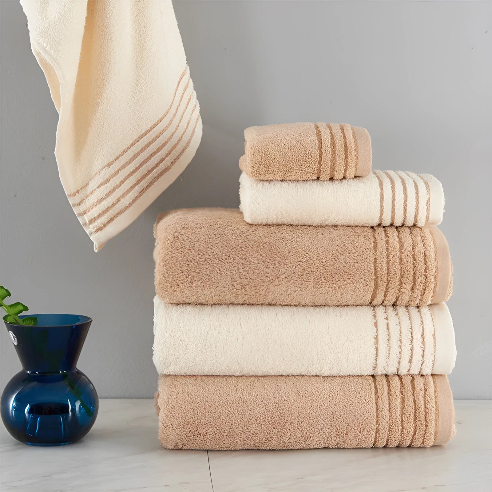 Beige and brown cotton towel set showing face cloth, hand towel and bath towel sizes.