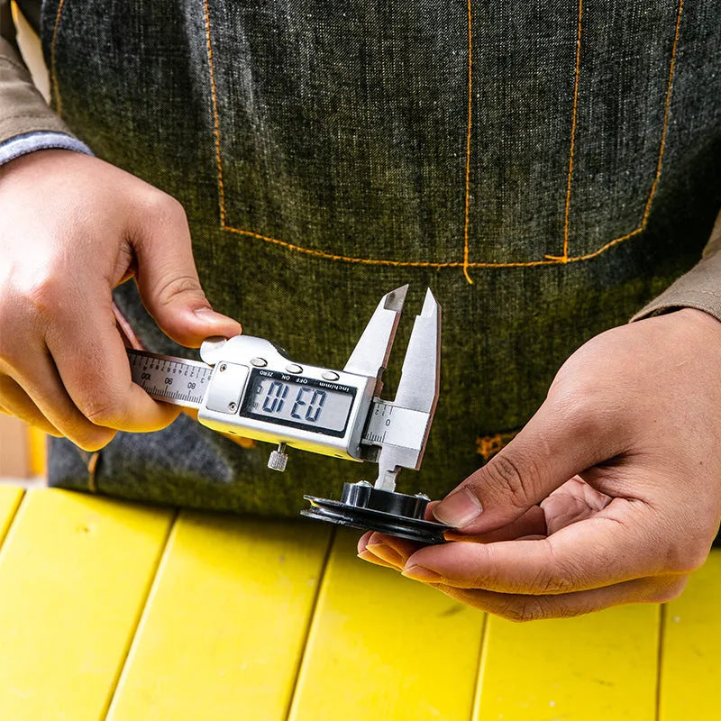 Deli stainless steel digital vernier caliper on a workshop bench showing 0.01mm resolution display.