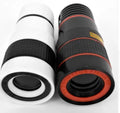 12X magnification black phone telescope lens with universal mounting clip and cleaning cloth on a table.