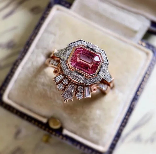 Rose gold geometric alloy women's ring with a retro ruby style on a grey background.