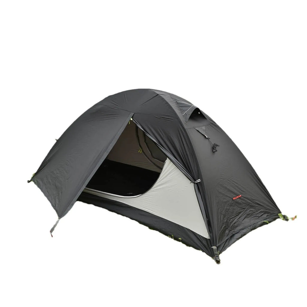 Red single person double-layer tent with aluminium poles set up outdoors.