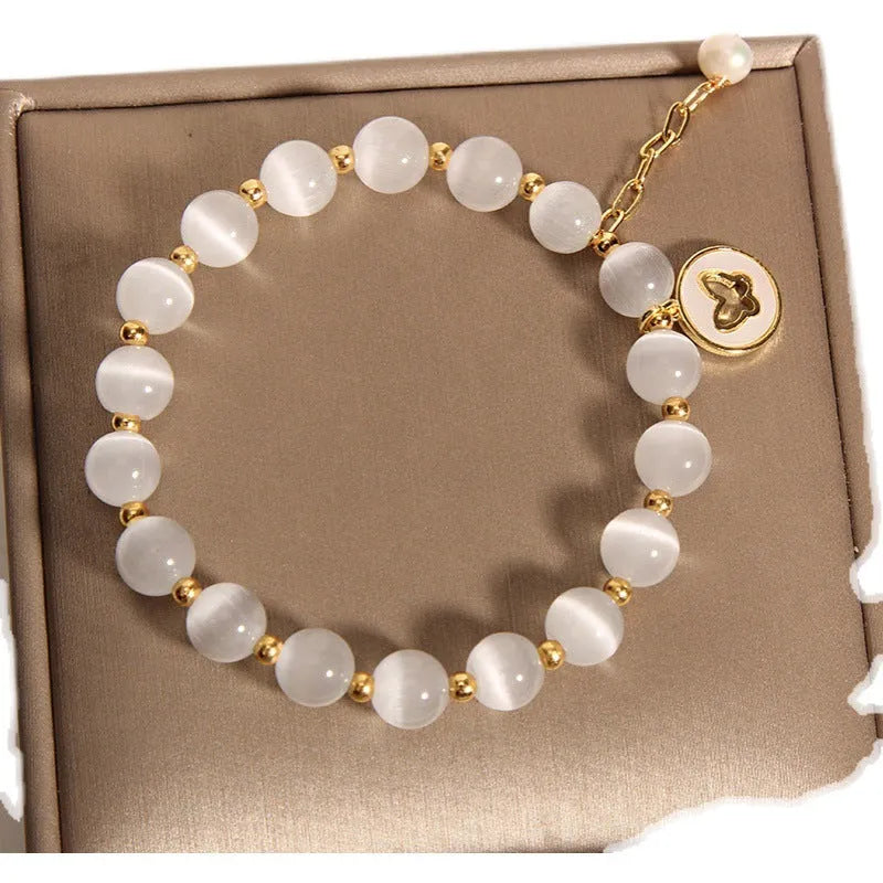 White geometric cat's eye crystal bracelet with a Korean-style design on a wrist.