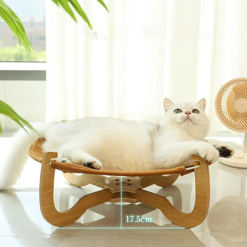 Brown woven rattan elevated hammock bed for cats and small dogs on a wooden floor.
