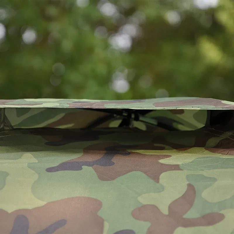 Green camouflage dome tent with mesh windows and steel ground nails setup outdoors