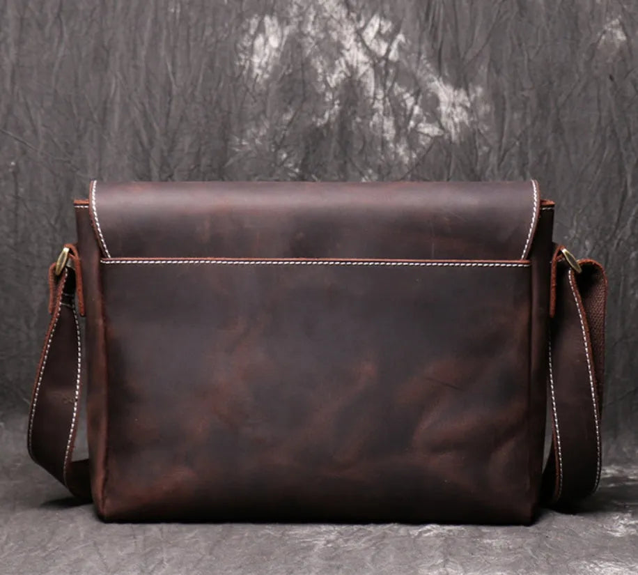 Vintage brown leather men's messenger bag with flap opening and adjustable shoulder strap.