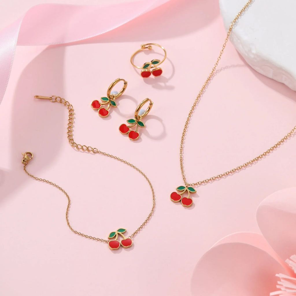 Stainless steel 18K gold plated cherry jewellery set showing necklace, bracelet, earrings, and ring.